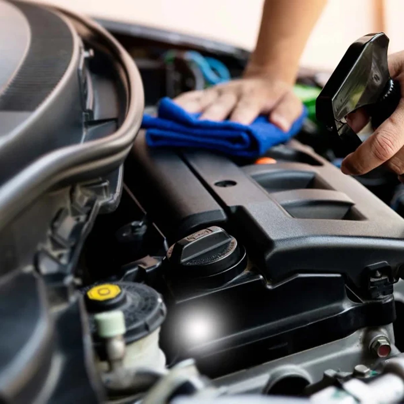 Service après-vente : nettoyage d’un compartiment moteur avec un chiffon microfibre bleu.
