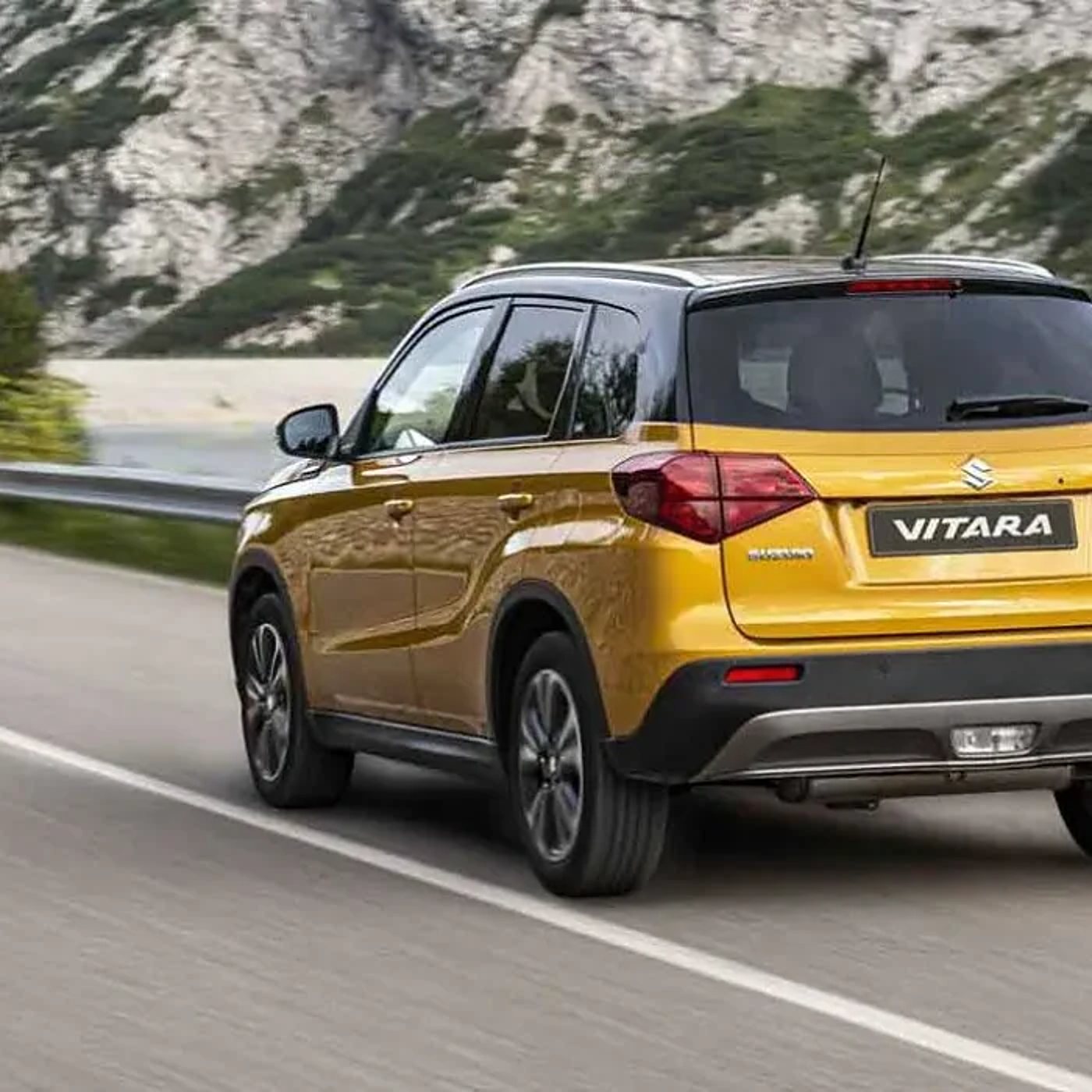 Les modèles Suzuki : un Vitara jaune sur une route de montagne.